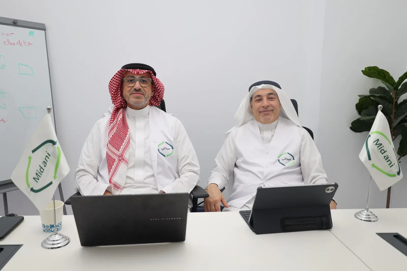 TICOM’s leadership at the office, with Midani flags on the desk.